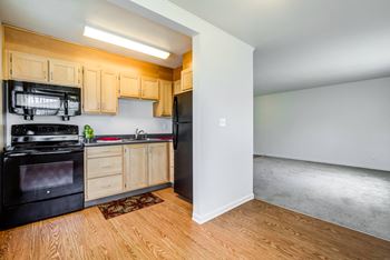 A kitchen with black appliances and wooden cabinets.